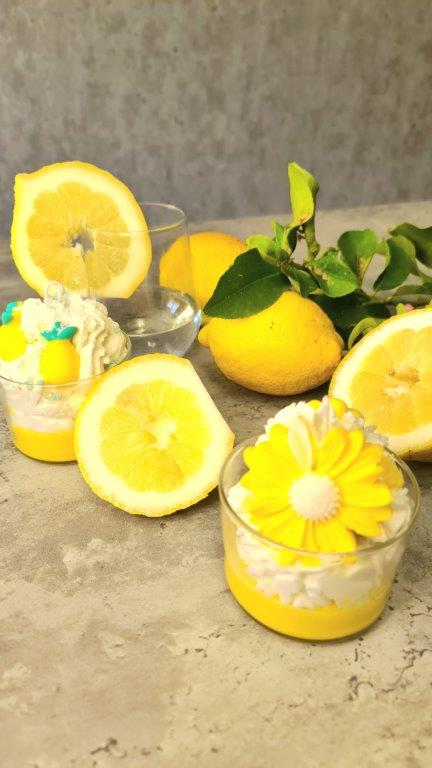 LAVURI® Zitronenbecher Duft- Kerze mit Schlagsahne und Mageriten Blüte in einem Glas