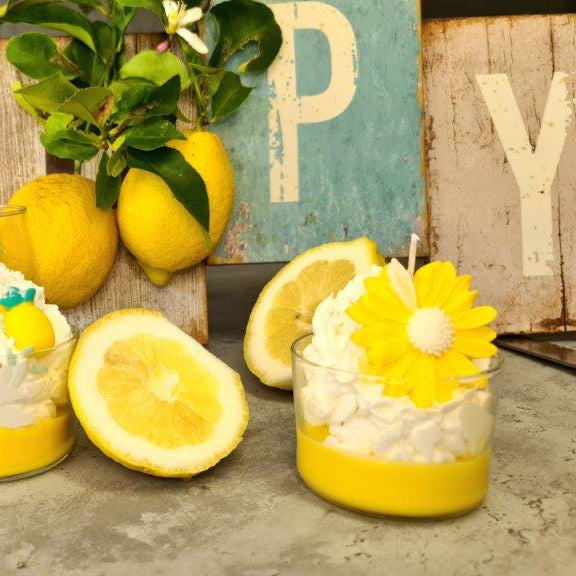 LAVURI® Zitronenbecher Duft- Kerze mit Schlagsahne und Mageriten Blüte in einem Glas